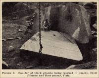 Boulder of black granite being worked in quarry
