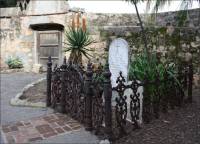 Marble cemetery stones in enclosed iron fence in the Santa Barbara Mission Cemetery, CA