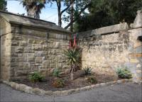 Sandstone and mortar wall & the side of the Covarrubias sandstone mausoleum in the Santa Barbara Mission Cemetery, CA